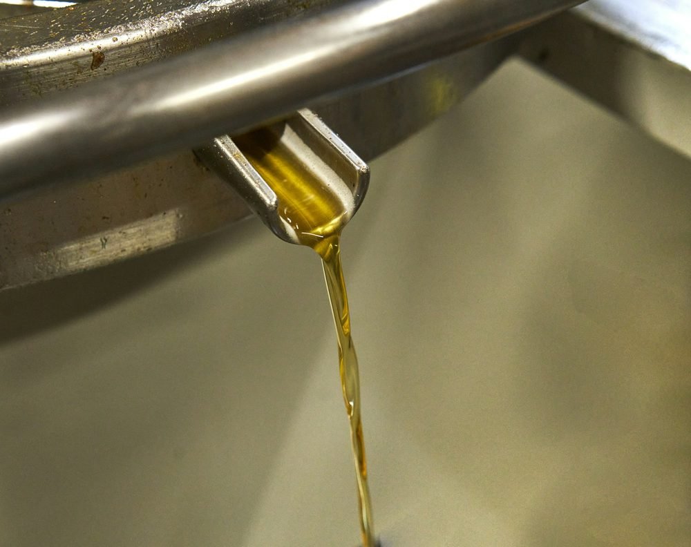 Edible oil pouring from a stainless pipe